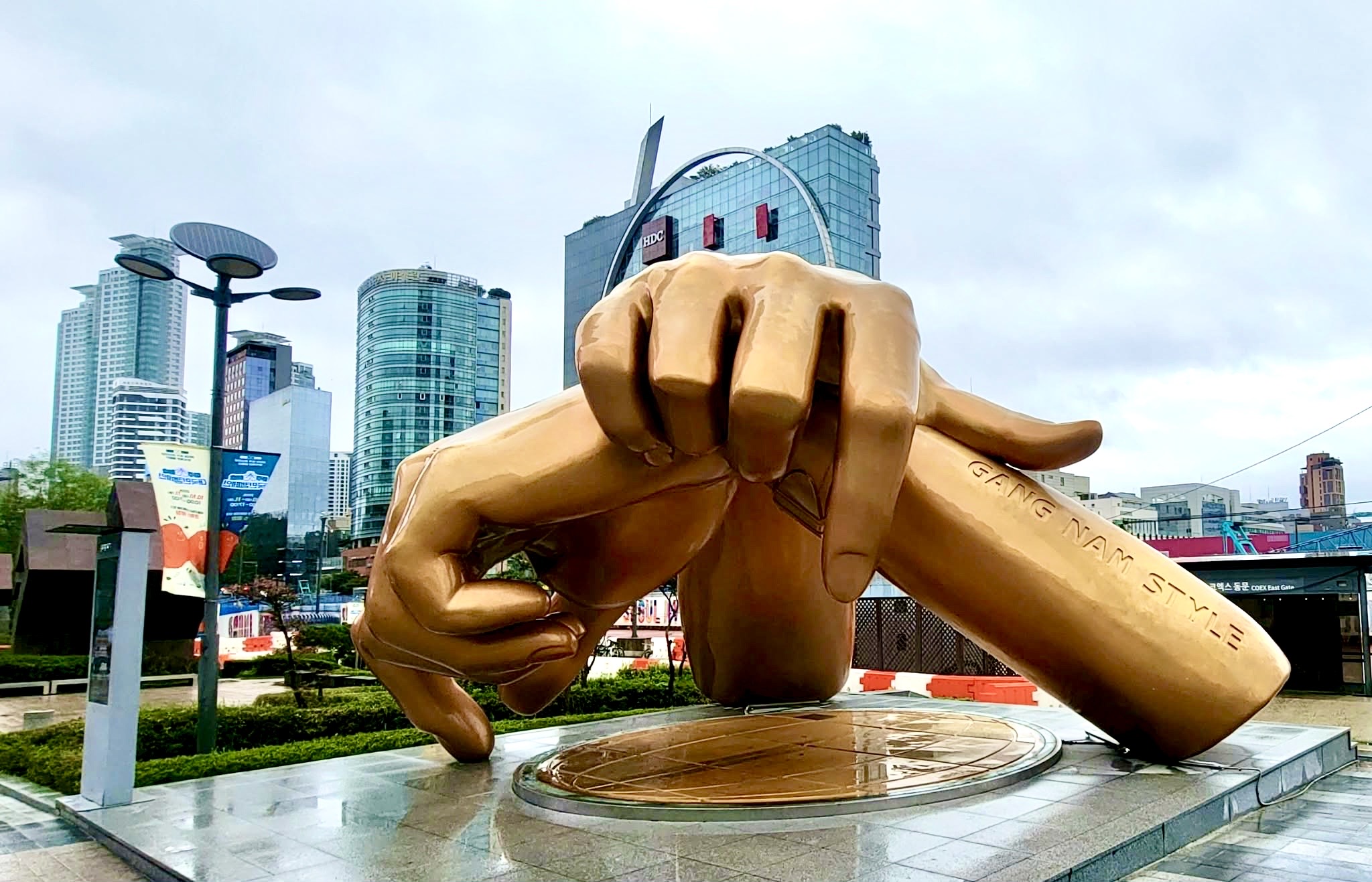 Escultura dorada de manos frente a los edificios de Gangnam, Seúl